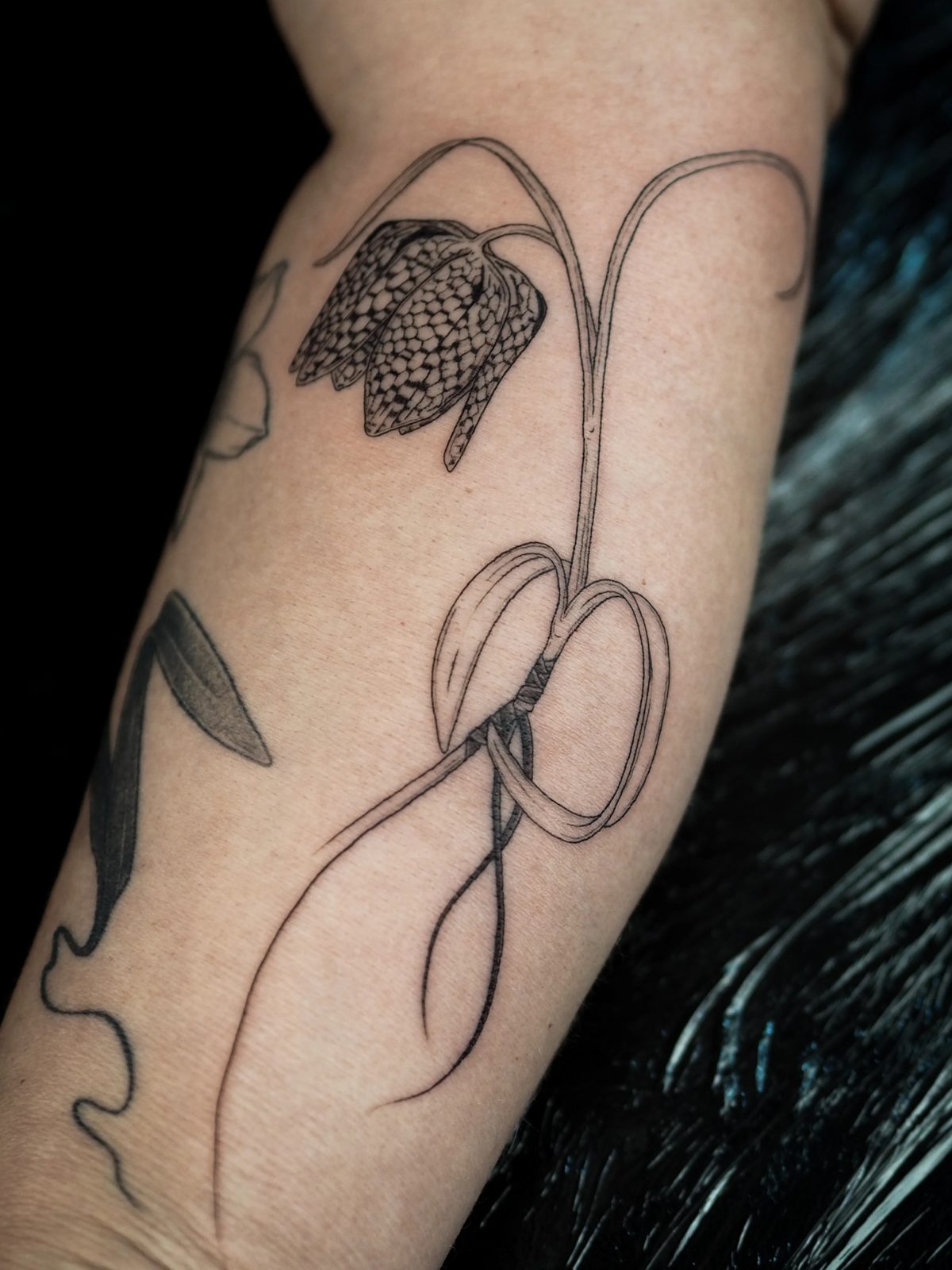 Tatuagem de flor fritillaria no antebraço