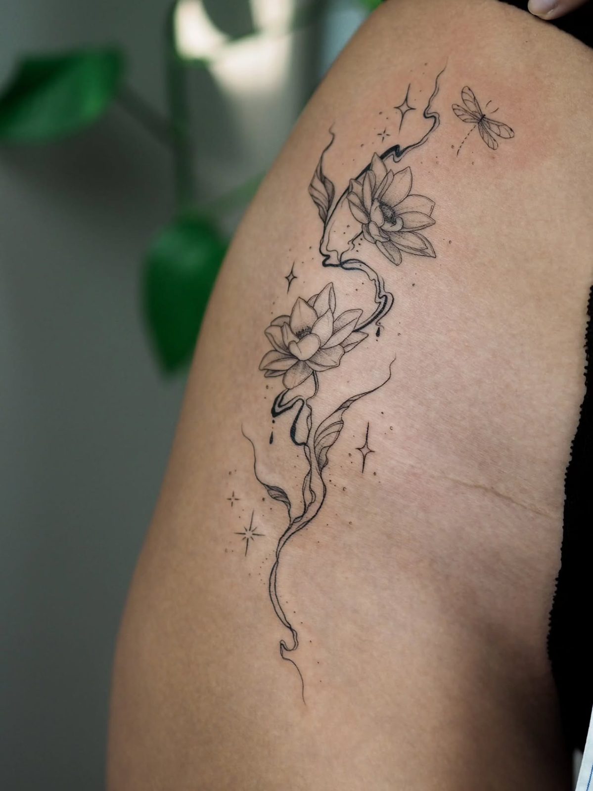 Tatuagem de flores de lótus e libélula no ombro